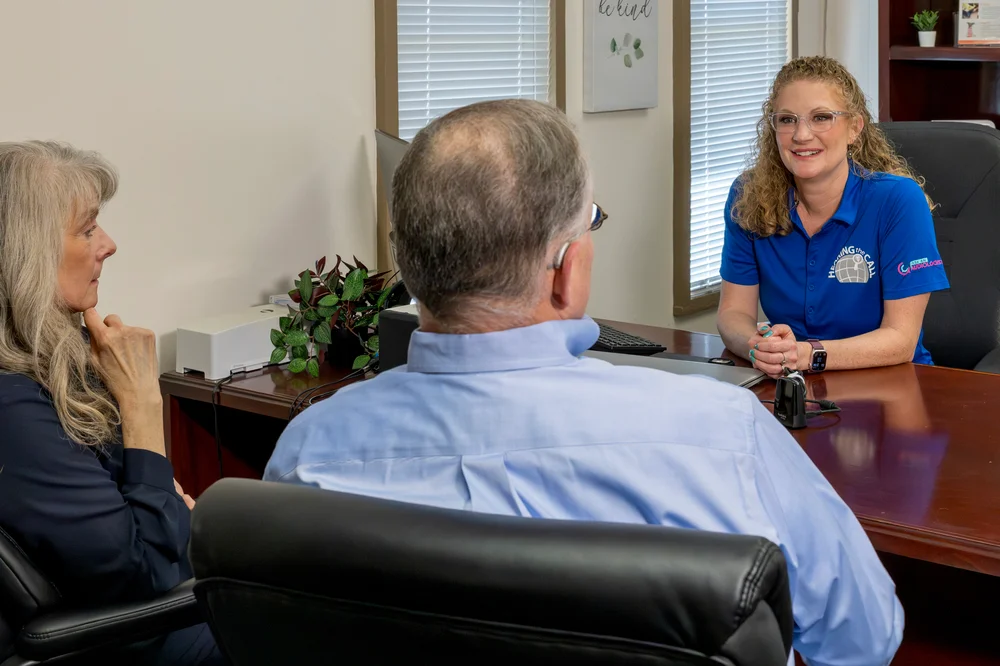 Audiologist discussing hearing care with a couple